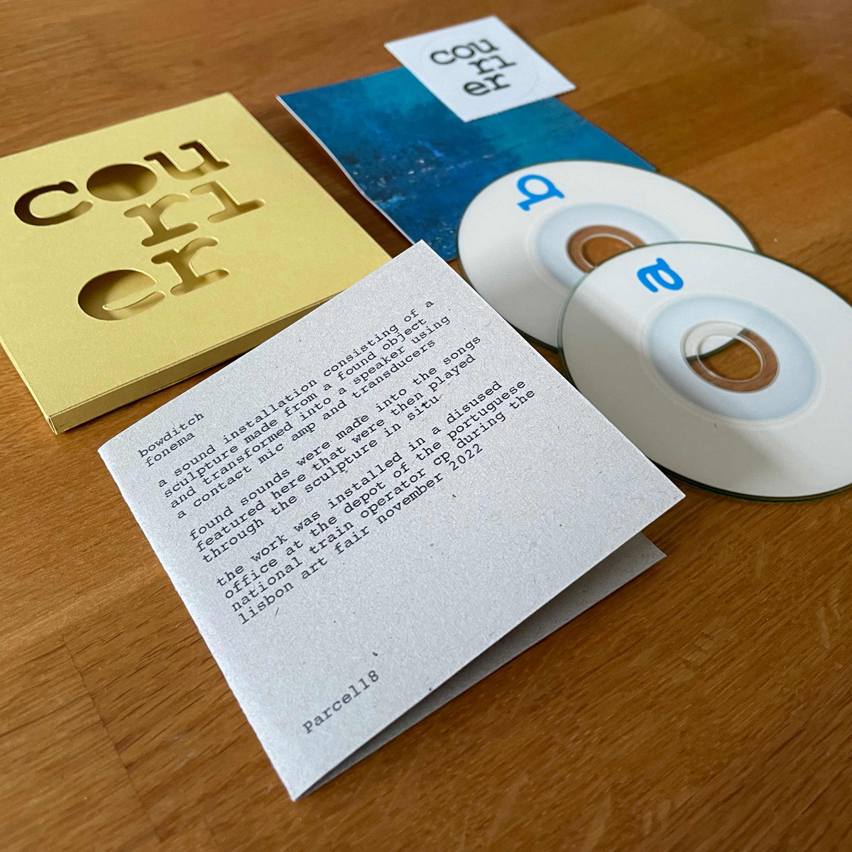 Photograph of a mini CD, yellow folded cover and printed text insert.